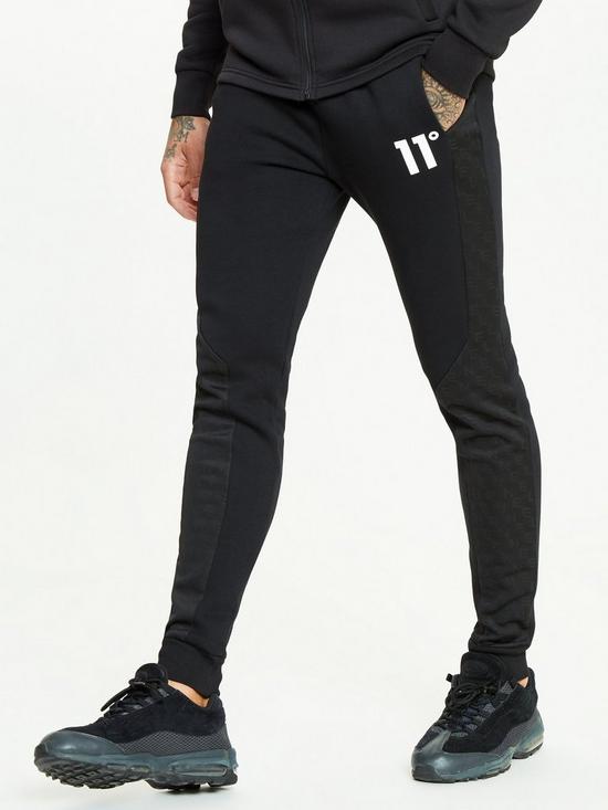 front image of 11-degrees-mixed-fabric-cut-and-sew-printed-skinny-fit-joggers-black
