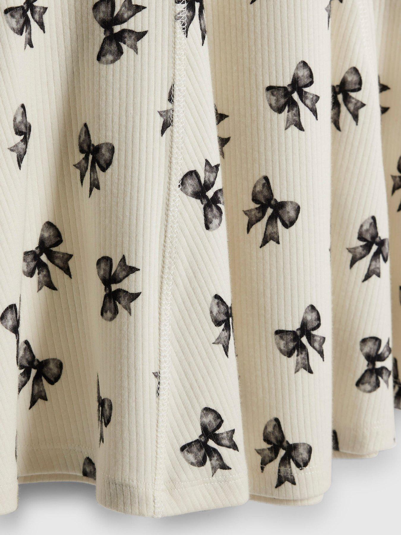Image 4 of 4 of River Island Older Girls Bow Print Ribbed Polo Dress - Cream