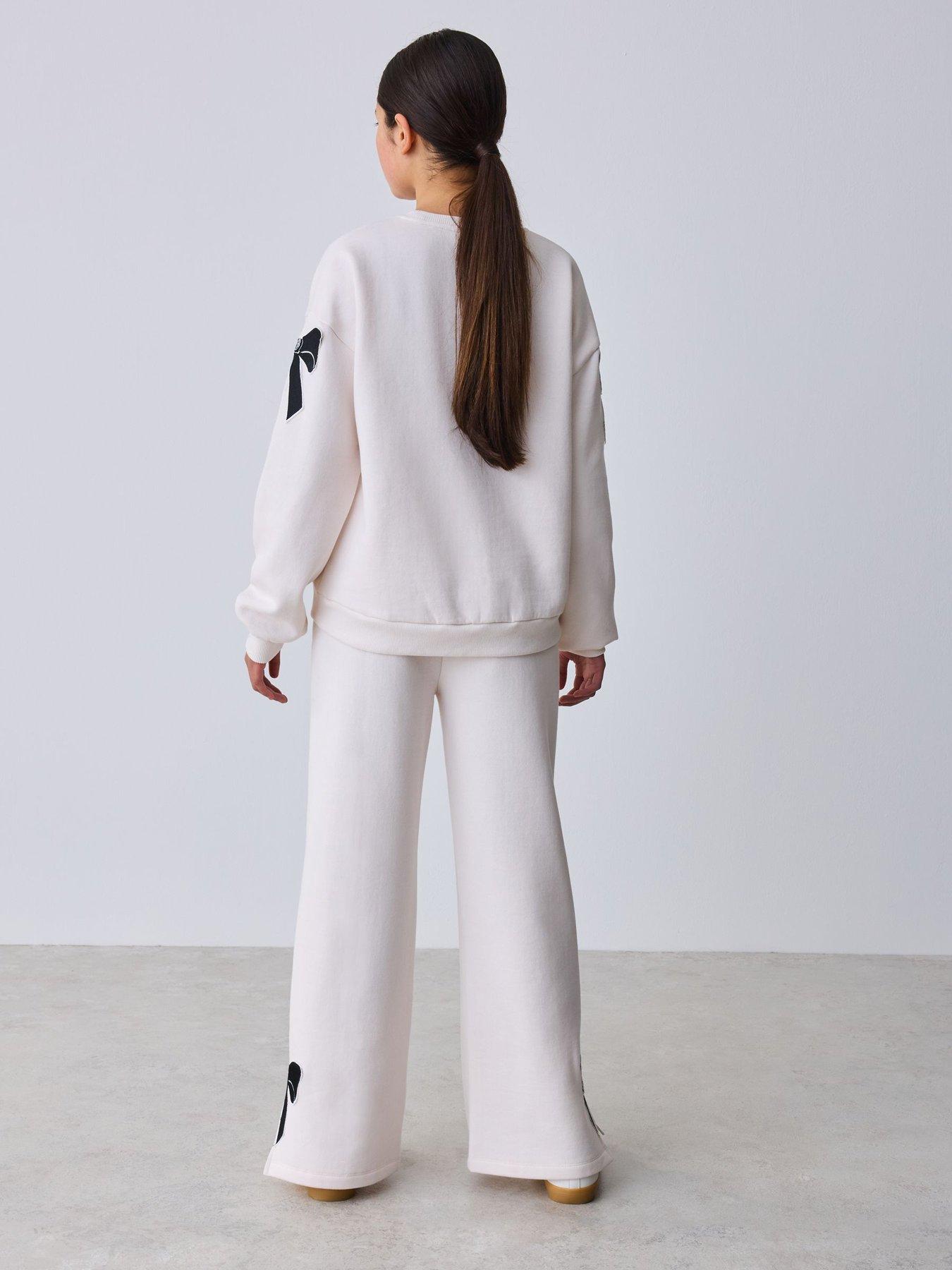 Image 2 of 7 of Ted Baker Girls Bow Detail Long Sleeve Sweatshirt Top and Split Hem Joggers Set - Cream